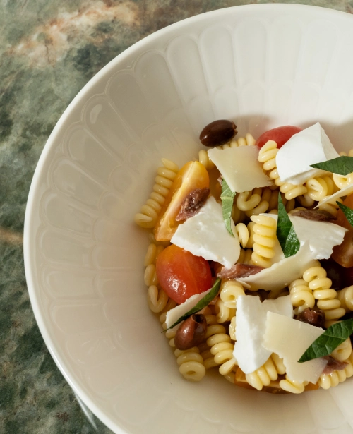 Cold pasta salad with shaved cheese and fresh greens at Osteria Da Su